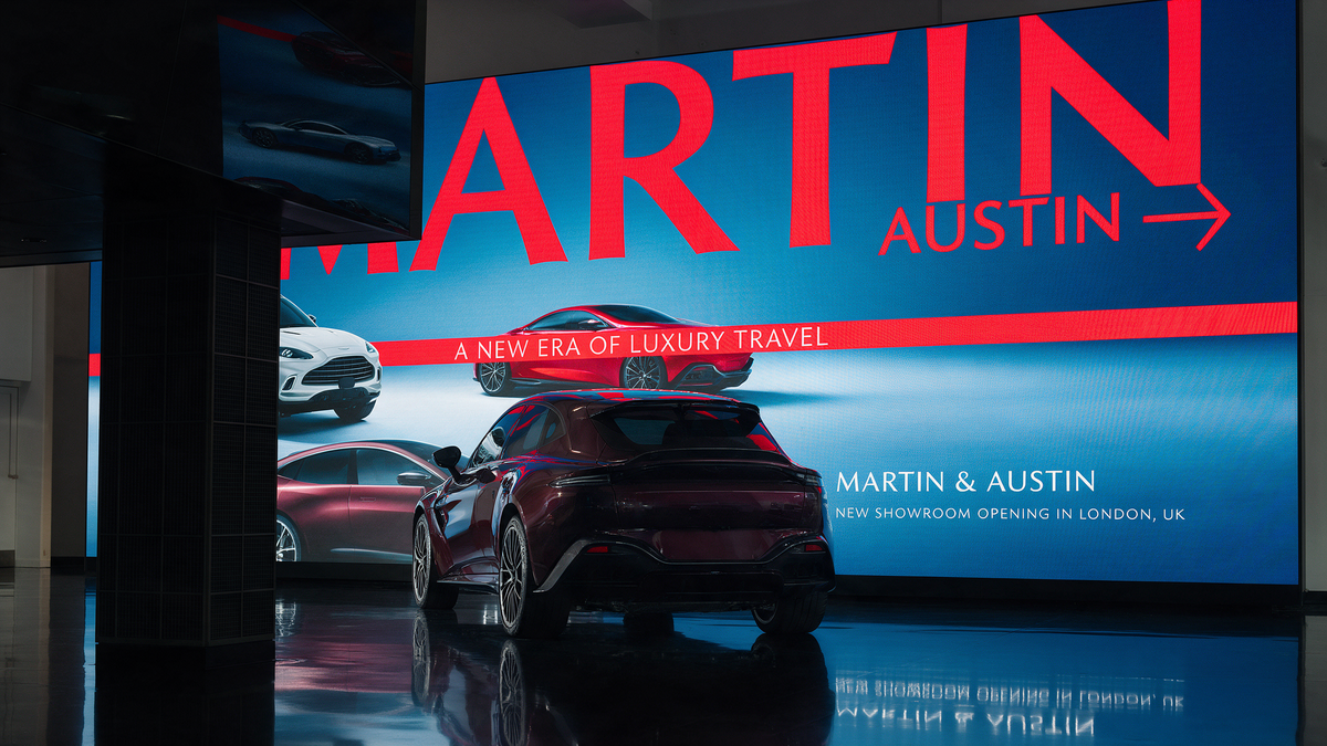 Luxury UK car dealership showroom with a seamless fine-pitch LED video wall behind a parked luxury vehicle